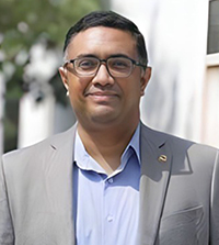 Close-up of a man wearing a suit and glasses.